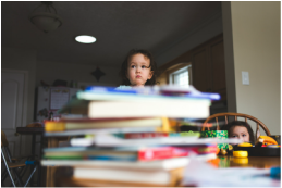 Child with pile of books